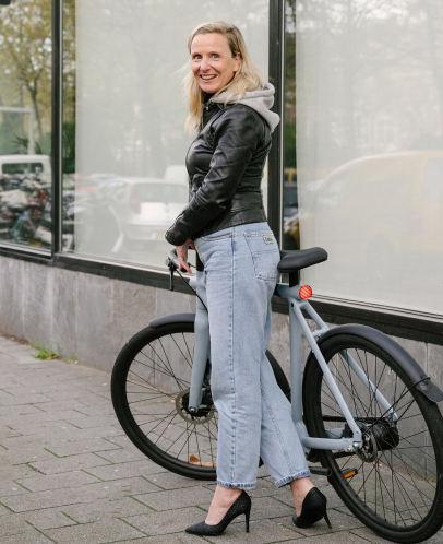 Woman standing outside with a bike