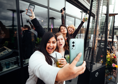 A group female coworkers taking a selfie on office rooftop